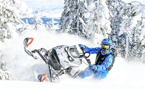 Rider riding up a snowy mountain on the 2027 Ski-Doo Summit
