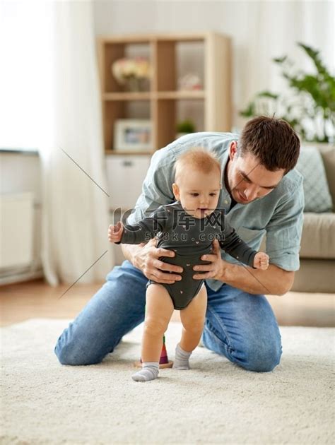 家庭、蹒跚学步和父亲的概念-父亲帮助小女儿在家走路。人物特写男孩高清摄影大图-千库网