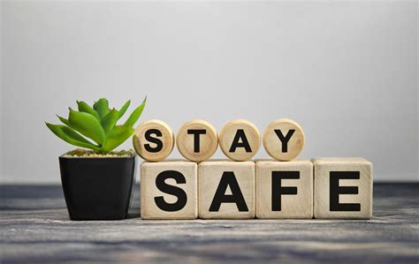 STAY SAFE - text on wooden cubes, green plant in black pot on a wooden ...