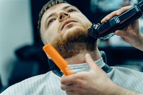 理发师在理发店用剃须机修剪胡须发型设计过程理发师剃胡子男胡高清图片下载-正版图片504596759-摄图网