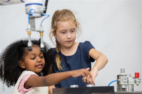 Kid female teen child enjoy Machine Learning Robot arm is Moving Under ...