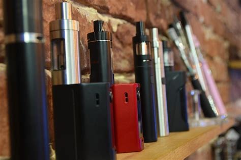 Electronic cigarette on a background of vape shop. e-cigarette for ...