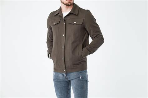 Man wearing green jacket with hands in pockets isolated on white ...