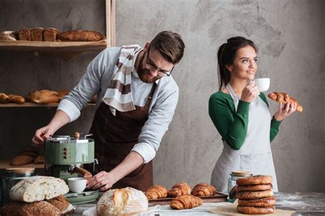 Liebevolle Paar Bäcker essen Croissants, die Kaffee trinken ...