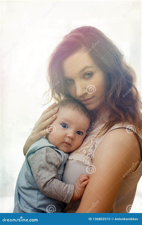 Pretty Woman Holding a Newborn Baby in Her Arms, Sunlight, Sunset Stock ...