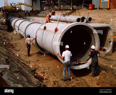 Pipe laying. Construction workers laying a pipeline Stock Photo - Alamy