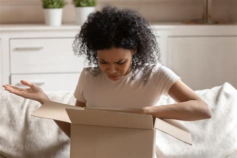 Angry african woman unpack carton box feels irritated | Premium Photo