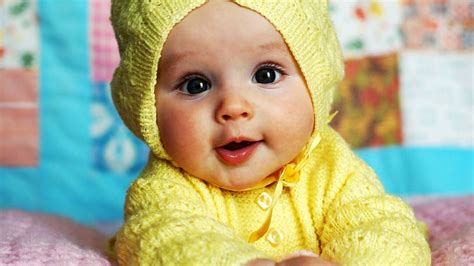 Cute Baby Is Wearing Yellow Knitted Wool Dress Lying Down On Bed In A ...