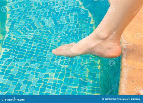 Young Girl Testing the Swimming Pool Temperature with Her Foot in the ...