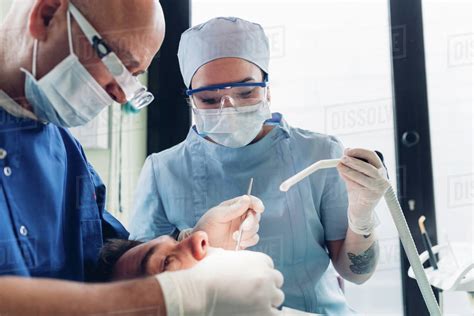 Dentist carrying out dental procedure on male patient, close-up
