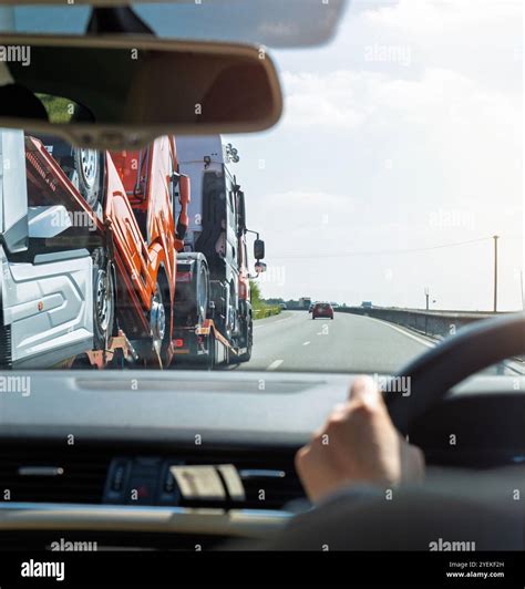 Point-of-view shot from a car interior following a truck transporter ...