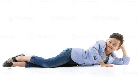 A 10-year-old Asian boy in a casual jacket is lying on the floor and ...
