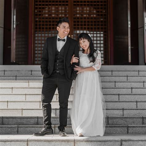 Front view of newlyweds posing together on steps | Premium Photo