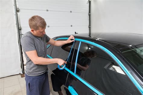A man of caucasian appearance with blue paper tape plasters a body ...