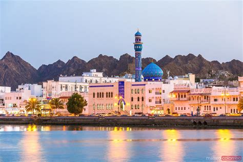 - Oman, Muscat. Mutrah harbour and old town at dusk | Royalty Free Image