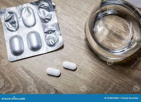 Antibióticos para infección urinaria junto a vaso de agua