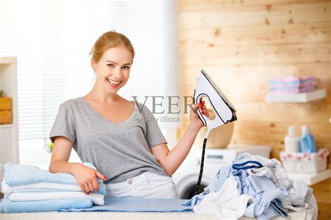 幸福的妇女家庭主妇在洗衣房里熨衣服照片摄影图片_ID:309655376-Veer图库