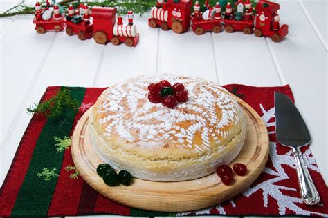 side view of Vaselopita - Greek New Years Cake dusted with powdered sugar with a slice cut out of it