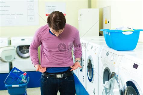 洗衣店里的年轻人洗脏衣服高清图片下载-正版图片502939096-摄图网