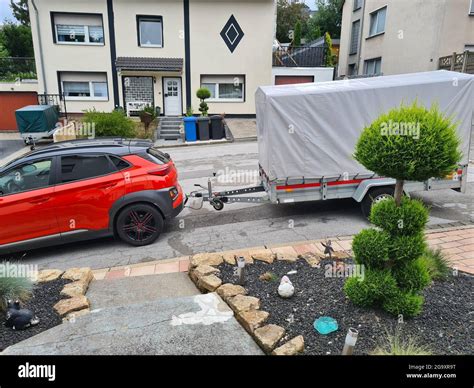 Compact SUV with gray awning single-axle trailer up close Car with trailer. Trailer with awning ...
