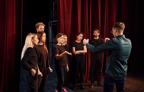 Group of actors in dark colored clothes on rehearsal in the theater ...
