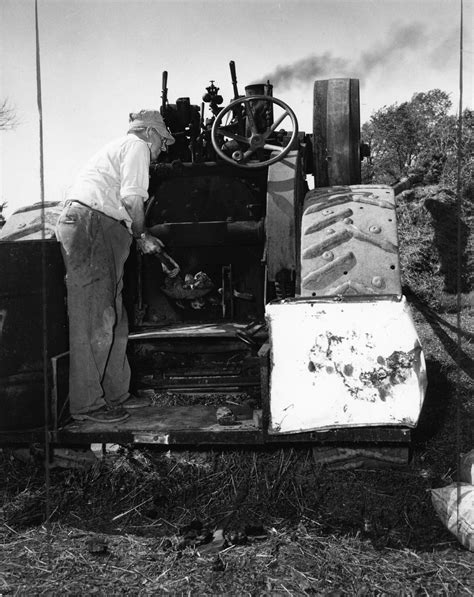Shoveling coal into a steam thresher near Watertown