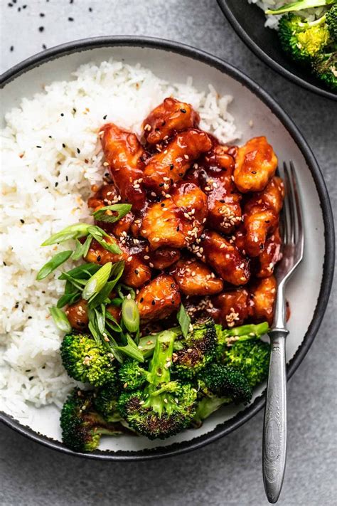 overhead plate of sticky sesame chicken with broccoli, green onions ...