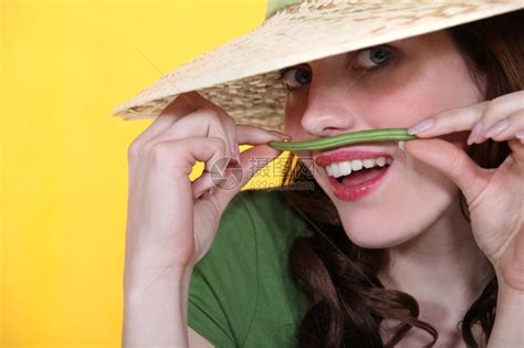 玩耍的女人拿着绿色豆子在她的上唇方高清图片下载-正版图片306935605-摄图网