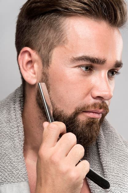 Homem de vista lateral raspando a barba | Foto Grátis