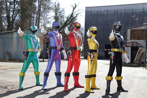 five people in different colored costumes standing next to each other