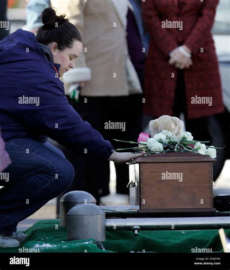 A woman spends a moment by the casket of Riley Ann Sawyers at the ...