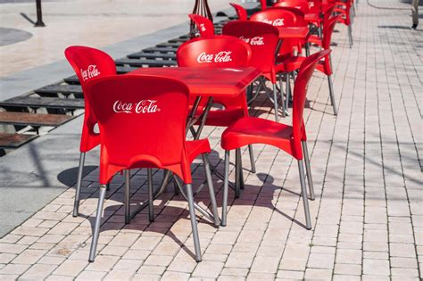 plastic red chairs and tables with Coca-Cola advertising logo in street ...