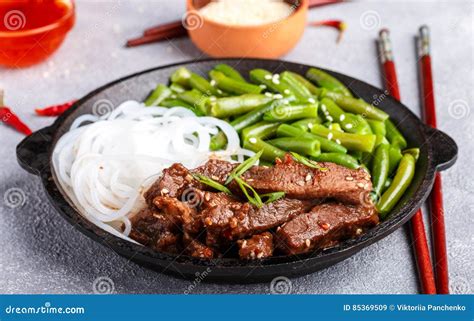 Fried Spicy Beef with Sesame Seeds, Green Beans and Rice Noodles Stock ...