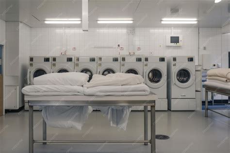 Public self service laundry with staff and bedding on a white bench ...