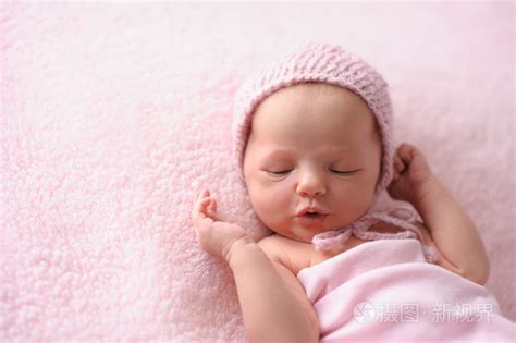 刚出生的婴儿女孩穿粉红色针织帽子照片-正版商用图片0s3xz2-摄图新视界