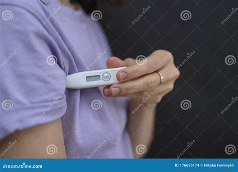 Girl Holds a Thermometer Under the Armpit. she`s Going To Measure the Temperature. the Concept ...