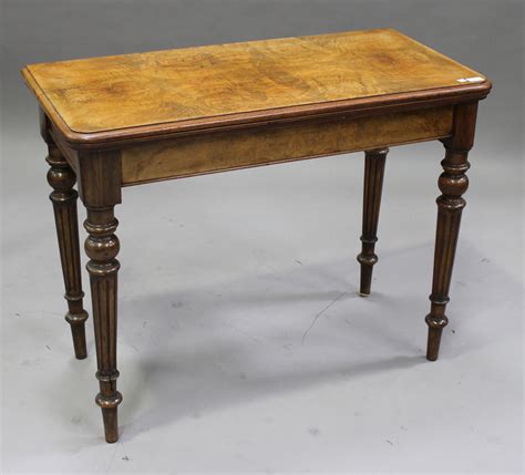 A late Victorian walnut rectangular card table, the top hinged to ...