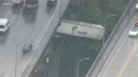 Semi-truck hangs over barrier after crashing on I-5 express lanes in ...