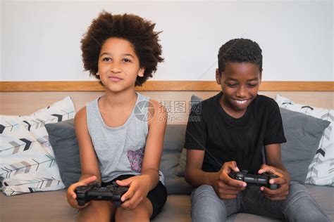 两个美国兄弟在家里玩电子游戏的肖像生活方式和技术概念高清图片下载-正版图片303607276-摄图网