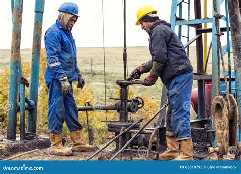 Oil Workers Check Oil Pump. Roustabouts Doing Dirty and Dangerous Work ...