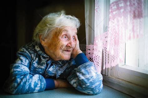 坐在桌子上看窗外的老妇人高清图片下载-正版图片505764327-摄图网