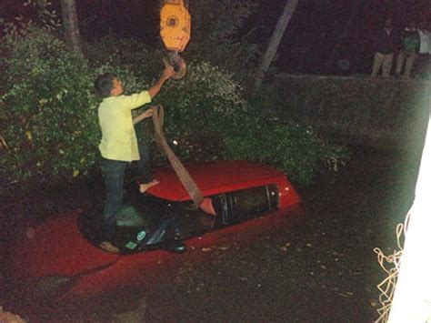 The car being removed from the culvert with the help of a crane.