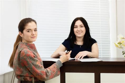 Portrait of two young smiling women. administrator of dental clinic and ...