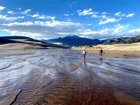 Crossing the seasonal Medano Creek in Great Sand Dunes National Park ...