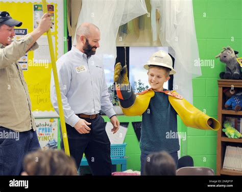 Fifth-grader Noah Basham, right, gets to try on some rubber sleeves and ...