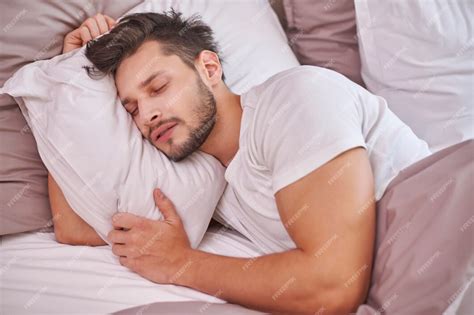 Free Photo | Exhausted man sleeping in his bed