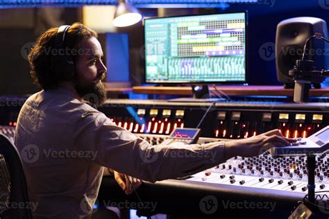 Sound engineer working in professional studio to mix and master tracks, expert editing music in ...