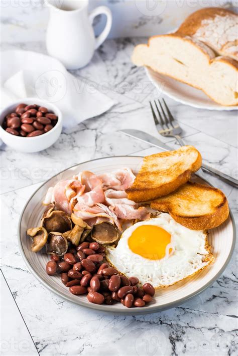 desayuno inglés con huevo frito, tocino, frijoles, champiñones y ...
