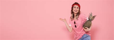 Linda garota em uma camiseta rosa, sorrindo com abacaxi | Foto Grátis