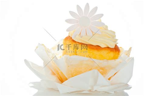 白色背景上带有香草奶油和糖花的纸杯蛋糕高清摄影大图-千库网